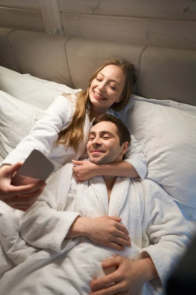 Krásná Žena Objímající Svého Krásného Manžela Krku Dělat Selfie Smartphone — Stock fotografie