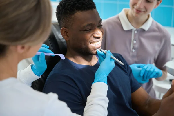 歯の健康と歯科探検家を使用して男性クライアントのエナメルの品質をチェックする女性歯科医 医師を支援 — ストック写真