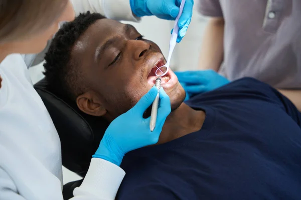 Qualifizierte Zahnärztin Untersucht Die Mundhöhle Des Männlichen Klienten Mit Mundspiegel — Stockfoto