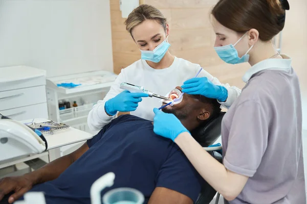 Enfermeira Cuidadora Segurando Ejetor Saliva Enquanto Mulher Dentista Usando Injetor — Fotografia de Stock
