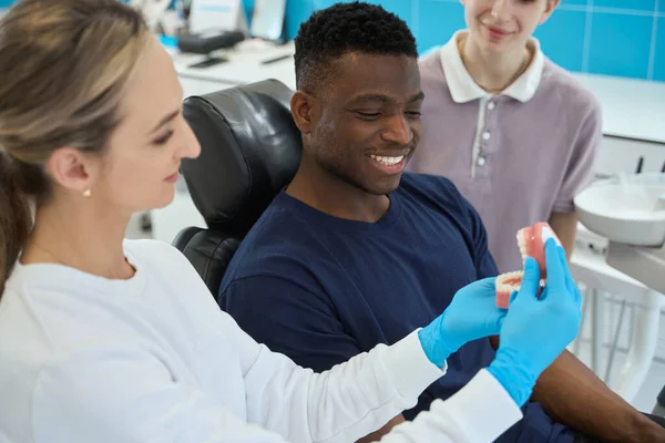 Mulher Hábil Estomatologista Mostrando Para Trabalho Cliente Masculino Mandíbula Dentes — Fotografia de Stock