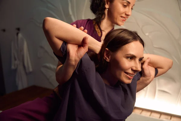 Smiling Client Sitting Hands Head While Friendly Masseuse Tilting Her — Stock Photo, Image