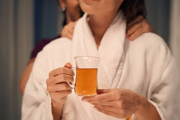 Cropped Photo Spa Customer Holding Glass Cup Drink While Massotherapist — Stock Photo, Image