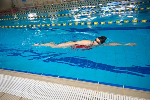 水で泳ぐフリースタイルで泳ぐスポーティな若い白人女性 — ストック写真