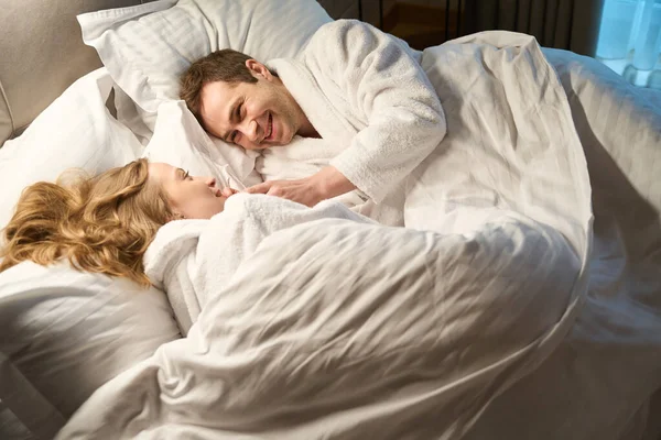 Romantyczna Zakochana Para Leżąca Łóżku Wielkich Miękkich Szlafrokach Uśmiechnięta Bawiąca — Zdjęcie stockowe
