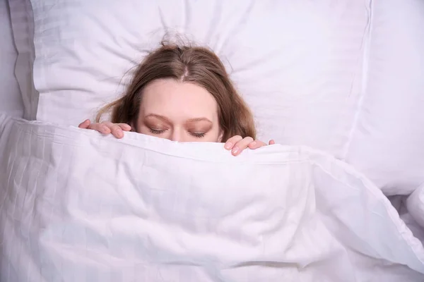 白い毛布で覆われた目を閉じた女性の顔のクローズアップ — ストック写真