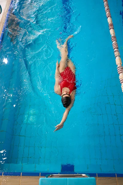泳衣和泳帽女运动员在游泳池中仰泳的头像 — 图库照片