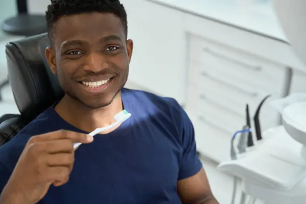 Американский Мужчина Держит Зубную Щетку Смотрит Камеру Улыбается Стоматологическое Обслуживание — стоковое фото