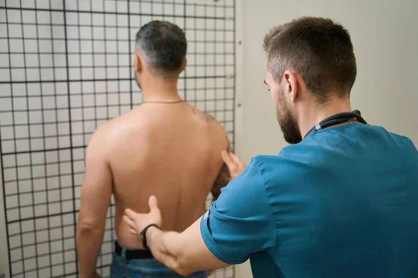 Erfahrener Physiotherapeut Führt Rückenuntersuchung Bei Männlichen Patienten Stehen Durch — Stockfoto