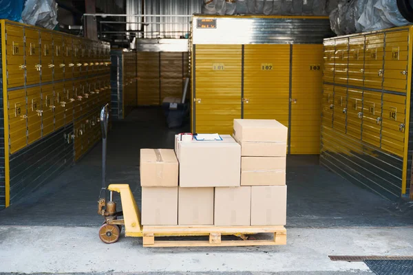 倉庫に積まれた貨物のトロリー そこに多くの段ボール箱およびタブレットがあります — ストック写真