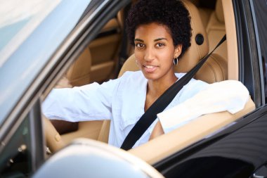 Zarif bir tasarım arabasında, rahat bir arabadaki Afro-Amerikan genç bayanı cezbediyor.