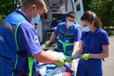 Sağlık görevlileri hastayı nakil için iyileştiriyor, kurban ambulansa bindiriliyor.