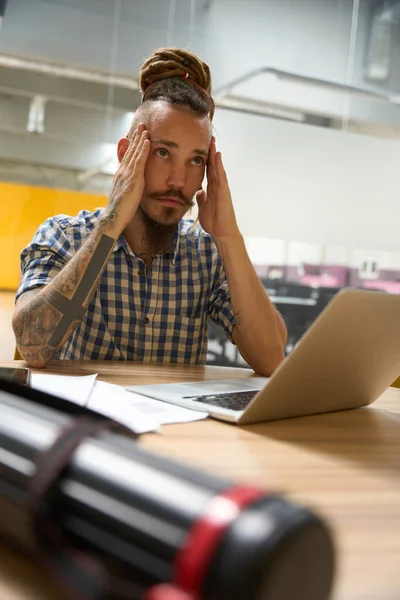Young Man Sits His Desk Suffers Headache Front Him Laptop — Stock Photo, Image