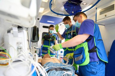 Ambulans ekibi, modern ekipmanlarla ambulansta bir hastayı hayata döndürüyor.