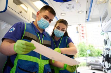 Sağlık görevlileri kurbanın kardiyogramını ve modern bir ambulansta sağlık görevlilerini inceliyor.