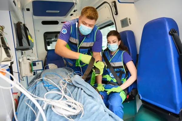 Paramédico Prende Paciente Uma Ambulância Uma Maca Com Cinto Segurança — Fotografia de Stock