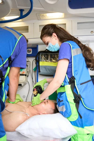 Cardiopulmonary resuscitation of a patient in an ambulance, paramedics doing cardiac massage