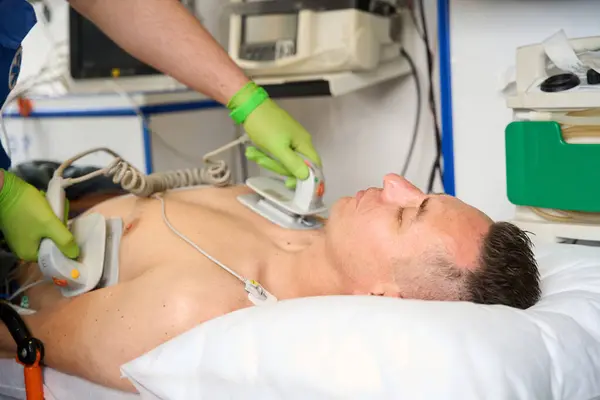 Paramedico Applica Elettrodi Defibrillatori Torso Paziente Mentre Esegue Rianimazione Cardiopolmonare — Foto Stock