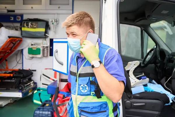 Man Paramedicus Communiceert Een Mobiele Telefoon Buurt Van Een Ambulance — Stockfoto