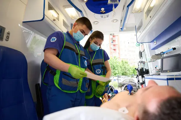 Equipo Paramédicos Hace Cardiograma Hombre Una Ambulancia Paciente Yace Bajo — Foto de Stock