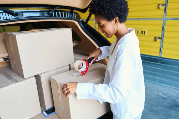 Lockenhaarige Frau Benutzt Klebeband Spender Kofferraum Liegen Viele Kartons Mit — Stockfoto