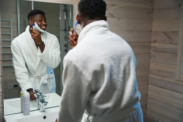 Young Man Shaves Front Large Mirror Bathroom Wearing Terry Robe — Stock Photo, Image