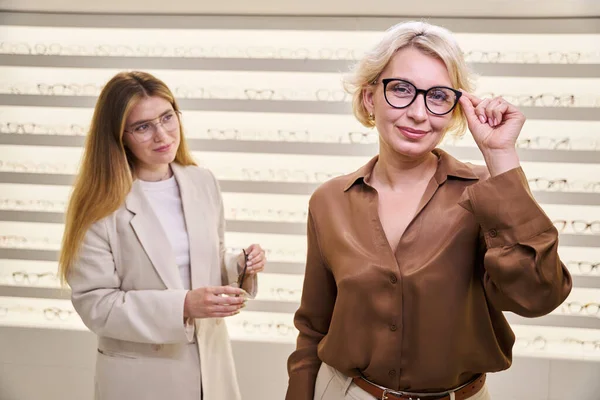 Medelålders Dam Provar Glasögon Optisk Salong Med Ögonläkare Närheten — Stockfoto