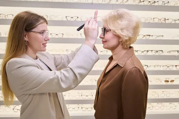 Kvinnlig Ögonläkare Kontrollerar Binokulär Syn Medelålders Dam Optiksalongen Finns Ett — Stockfoto