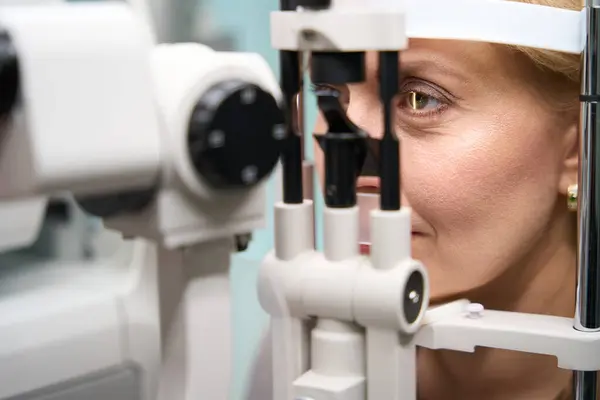 女人的头被固定在一种特殊的眼科器械前 一种与眼科医生预约的女士 — 图库照片