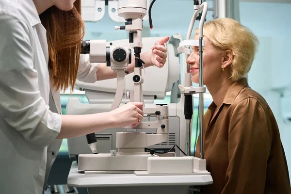 stock image Ophthalmologist uses a diopter meter in his work, the client sits opposite the device