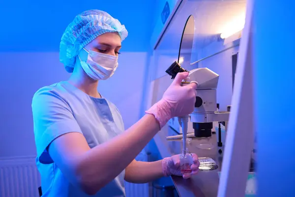 無菌手袋の研究者および液体解決が付いているガラス瓶にピペットの先端を浸す医学のマスク — ストック写真