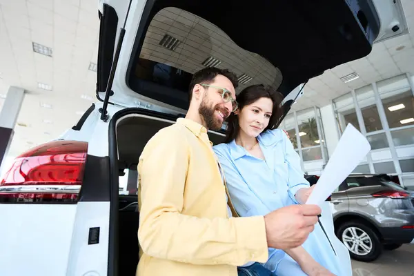 Caucasian Woman Man Reviewing Paper While Leaning Trunk Auto Car — Stock Photo, Image