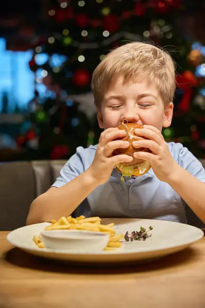 Голодный Маленький Ребенок Наслаждается Большим Гамбургером Время Празднования Рождества Уютном — стоковое фото