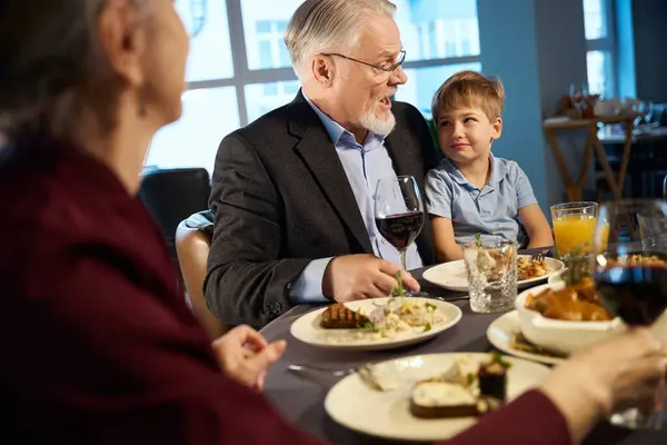 Hymyilevä Vanha Mies Pieni Poika Istumassa Juhlapöydässä Ravintolassa Juhlimassa Uutta — kuvapankkivalokuva