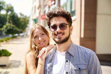 Sıcak bir yaz gününde şehirde kameraya bakan beyaz bir çiftin portresi. Romantik ilişki ve randevu kavramı