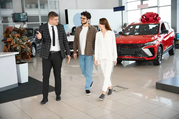 Happy Delighted Couple Dealer Walking Showroom Choosing Car Woman Gist — Stock Photo, Image