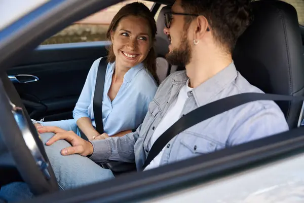 年轻的 面带微笑的高加索男人和女人在车里互相望着对方 恋爱关系的概念 道路旅行 旅行和度假的想法 — 图库照片