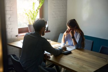 Young caucasian male boss have meeting with crying female employee during work at desk in coworking office. Concept of teamwork