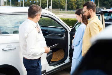 Buyers inspect the interior of the car, they are advised by a customer relations manager
