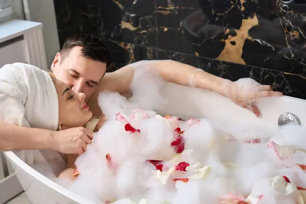 Happy Newlyweds Soak Foam Bath Rose Petals Man Gently Hugs — Stockfoto