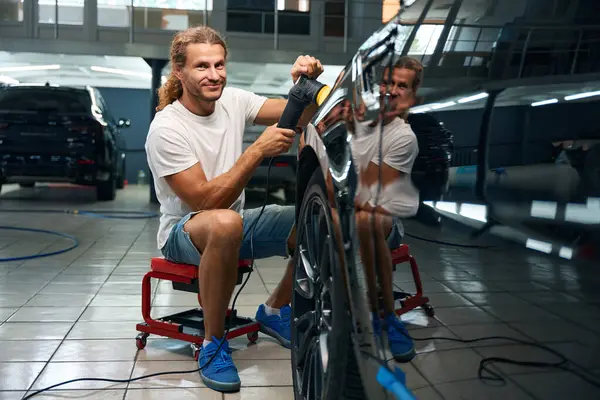 Young Man Detailing Black Car Using Mobile Chair His Work — Stock Photo, Image