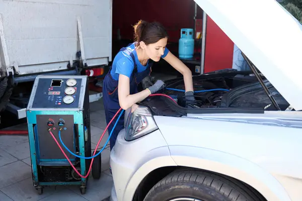 Kobieta Mechanik Samochodowy Kombinezonach Napełnia Klimatyzator Samochodowy Używa Specjalnego Sprzętu — Zdjęcie stockowe