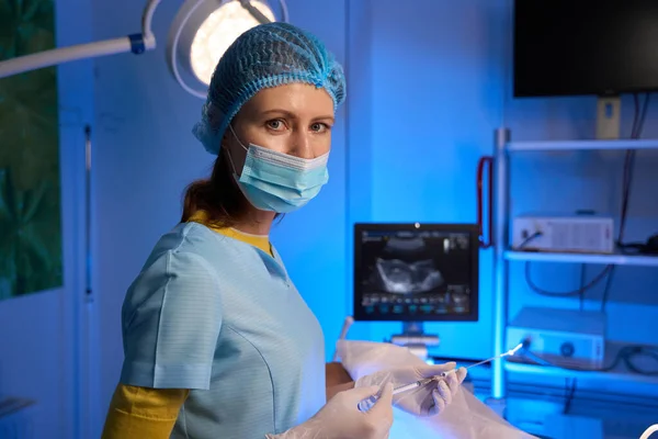 胚移植のための注射器を使用し 生殖クリニックでカメラを見ている女性医師の部分的な側面のビュー エンベロジーとバイオテクノロジー — ストック写真