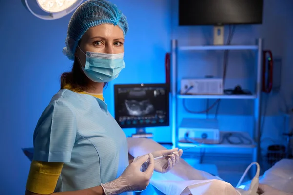 人工受精のための注射器を使用し 生殖クリニックでカメラを見る女性医師のクロップされた側面のビュー エンベロジーとバイオテクノロジー — ストック写真