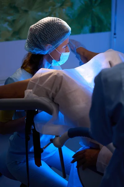 女性医師は 生殖クリニックの医療ソファーで部分的な女性患者の胚移植を行っています エンベロジーとバイオテクノロジー — ストック写真