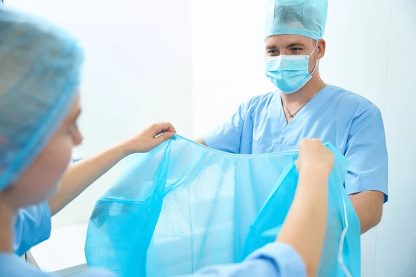 Cropped Female Nurse Helping Male Doctor Put Medical Gown Surgery — Stock Photo, Image