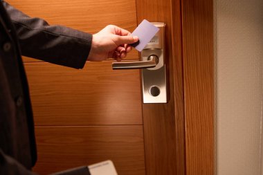 Otel odasının kapısını elektronik plastik anahtarla açmaya çalışan adamın fotoğrafını çek.