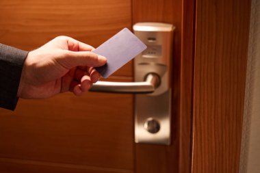 Otel odasındaki kapının dijital kilidini açan adamın fotoğrafını anahtar kartın yardımıyla kapat.
