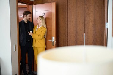 Neşeli kadın ve adam otel odasına girdiler ve birbirlerine bakarak kapıyı açtılar.