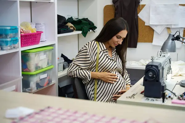 ワークショップで妊娠した職人 ミシンで働く アトリエには現代的な機器があります — ストック写真